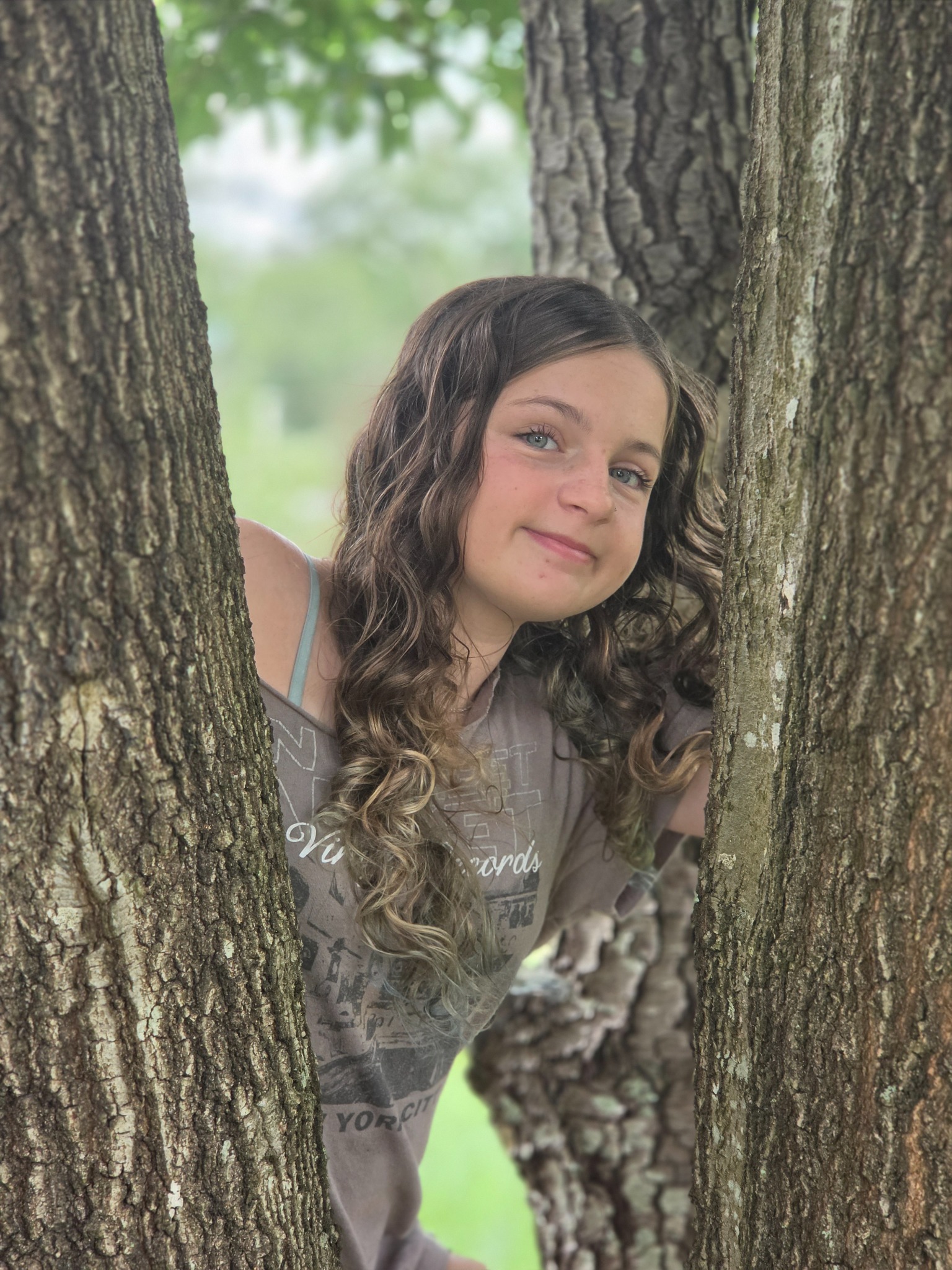 Caitlyn Helms smiling between two tree trunks
