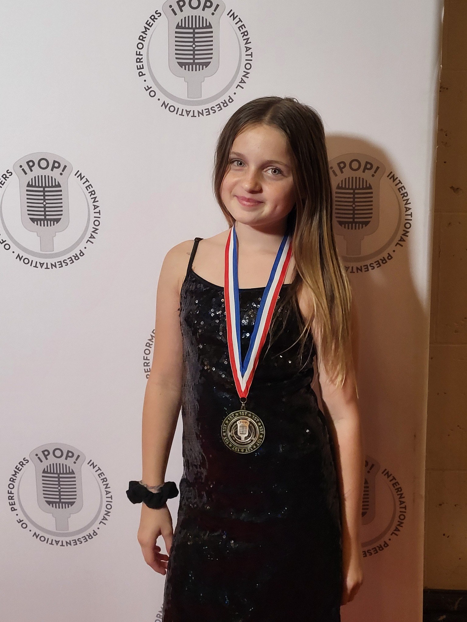 Caitlyn Helms wearing her iPOP first-place medal